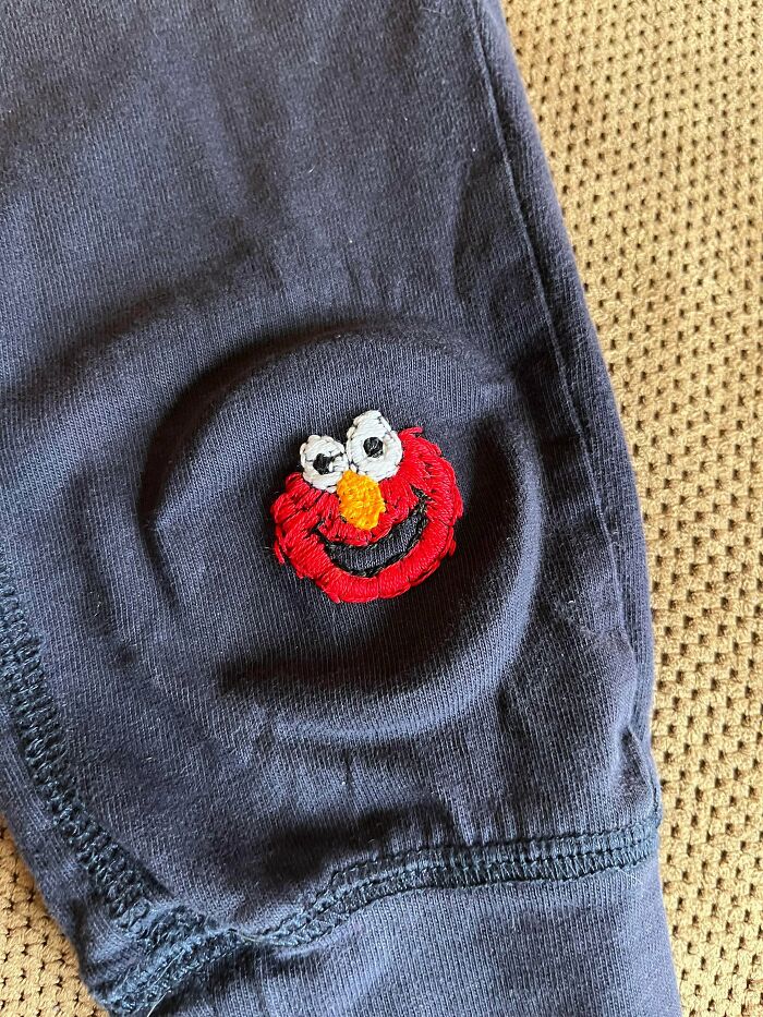 Hand embroidered Elmo patch on dark clothing showing DIY creativity to save money