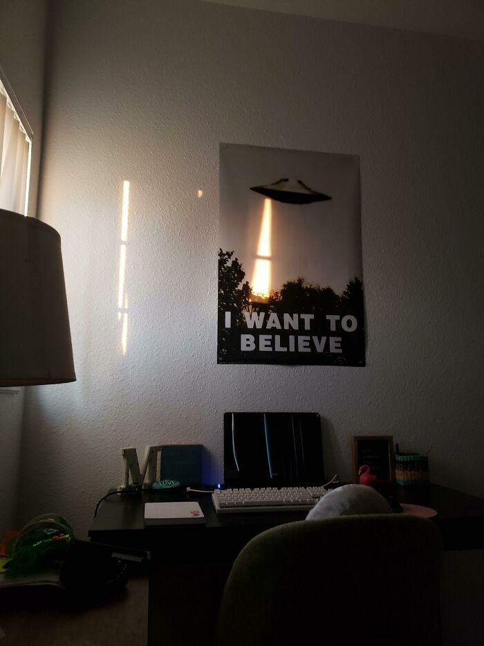UFO poster lit by sunlight beam creating illusion glitch