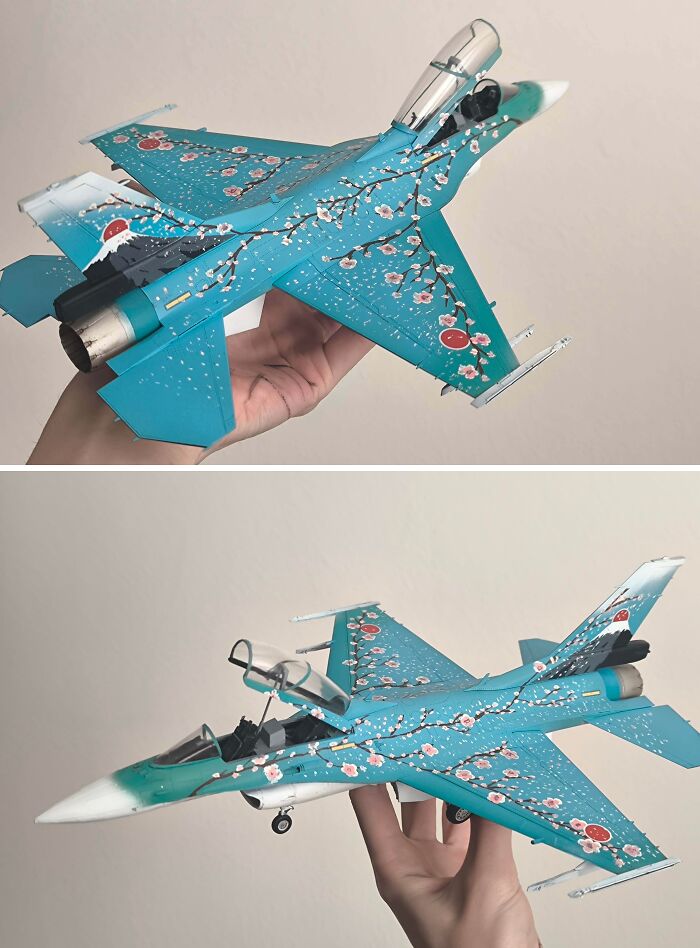 Miniature model of a fighter jet with detailed cherry blossom design on wings and body