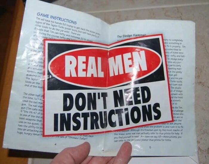 A game manual covered by a sticker saying REAL MEN DON'T NEED INSTRUCTIONS, creating confusing instructions
