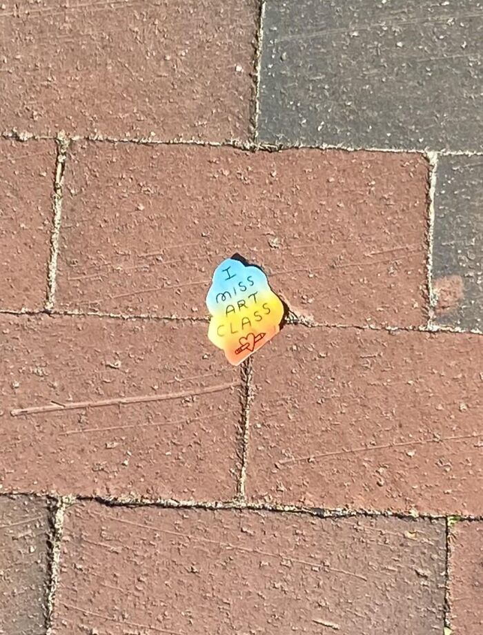 A colourful sticker on the pavement reading I miss art class, showcasing found paper.
