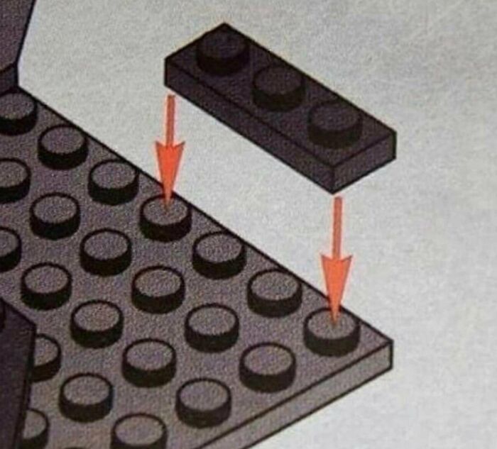 A toy brick diagram displaying confusing instructions for placing a piece onto a baseplate with red arrows.