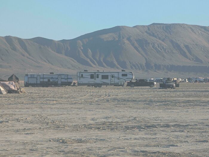 Multiple travel trailers parked in a desert flatland, highlighting towing gone wrong setups.