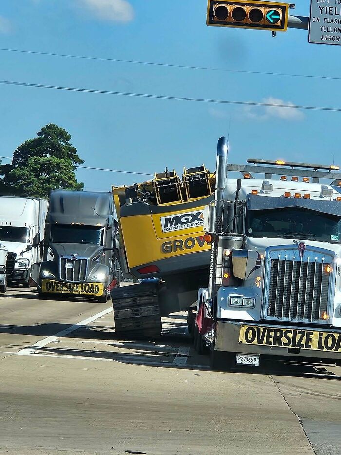 An example of towing gone wrong with a semi truck carrying heavy machinery tilting sideways.