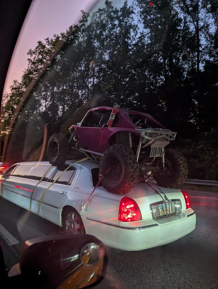 Off-road buggy strapped precariously to the roof of a white stretch limousine in towing gone wrong moment