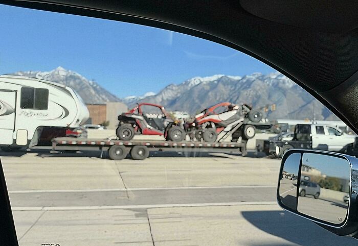 A trailer carrying off-road vehicles on a highway, demonstrating an example of towing gone wrong.
