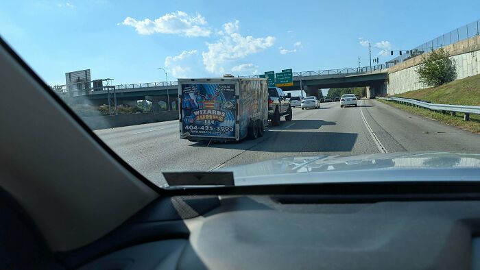 Pickup truck pulling a trailer with missing or flat tires on a highway, showing towing gone wrong.