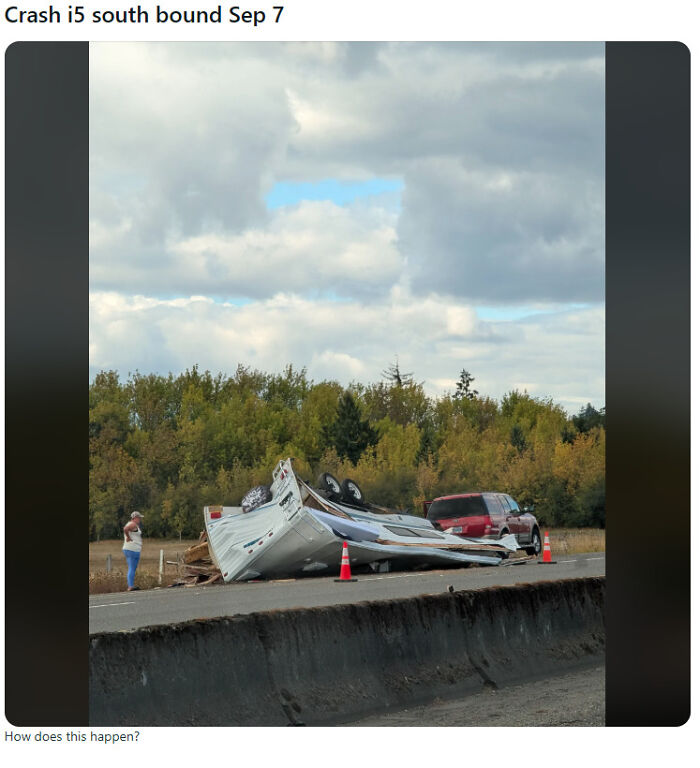 An overturned camper trailer flipped upside down on the highway, a classic case of towing gone wrong.