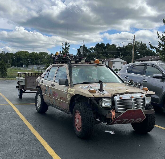 A heavily modified sedan towing a makeshift trailer in a bizarre towing gone wrong scenario.