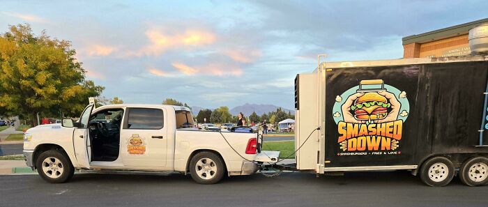 A white truck towing a large Smashed Down food trailer, illustrating towing gone wrong