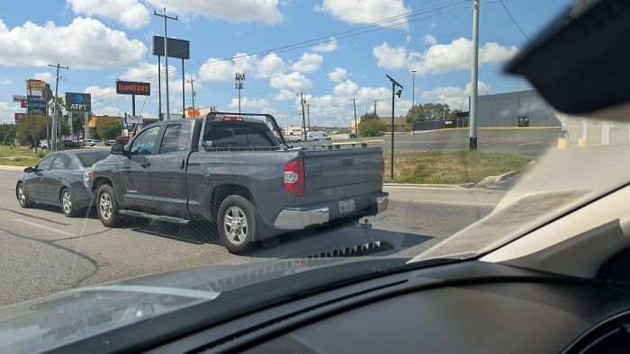 Pickup truck driving on road with tow hitch attached, showing towing gone wrong setup.