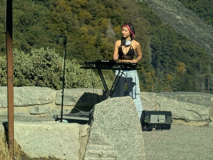 Influencers in public spaces setting up DJ equipment and recording content outdoors in a scenic mountain park
