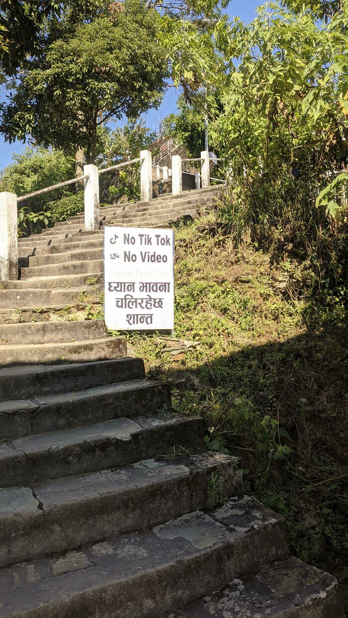 Outdoor stone staircase featuring a sign banning TikTok videos in public spaces.