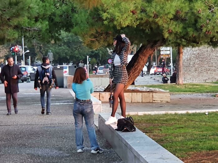 Woman in plaid outfit posing in public spaces while someone takes photos.