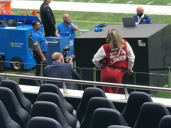 Woman in red pants posing as influencers film photos in public spaces.