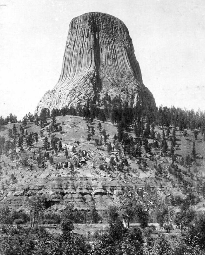 A historic black and white photo of Devils Tower rock formation, highlighting cool history facts.