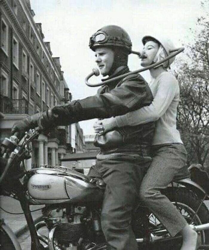 A couple riding a motorcycle using an acoustic communication tube, a weird fact from history.