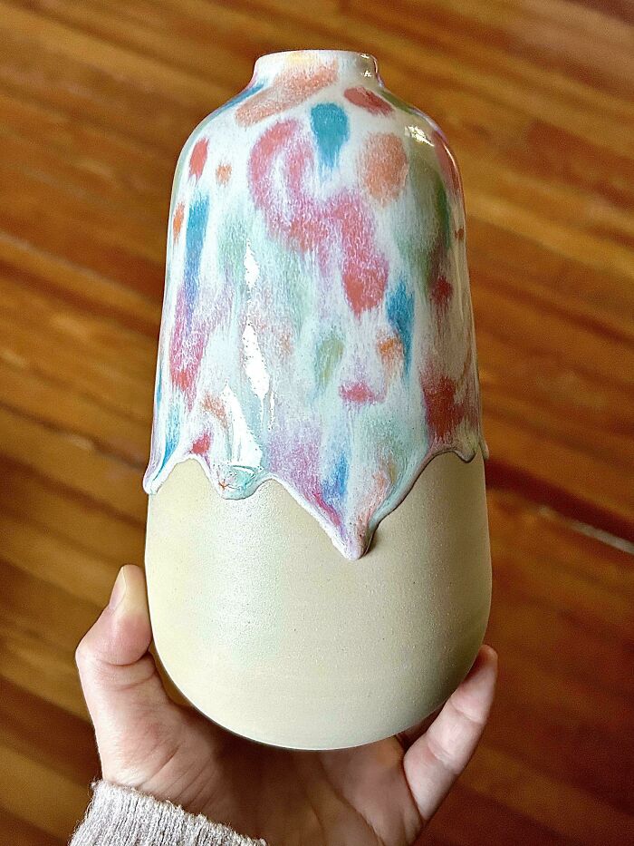Colorful drip glazed vase highlighting creative pottery creations on a wooden table