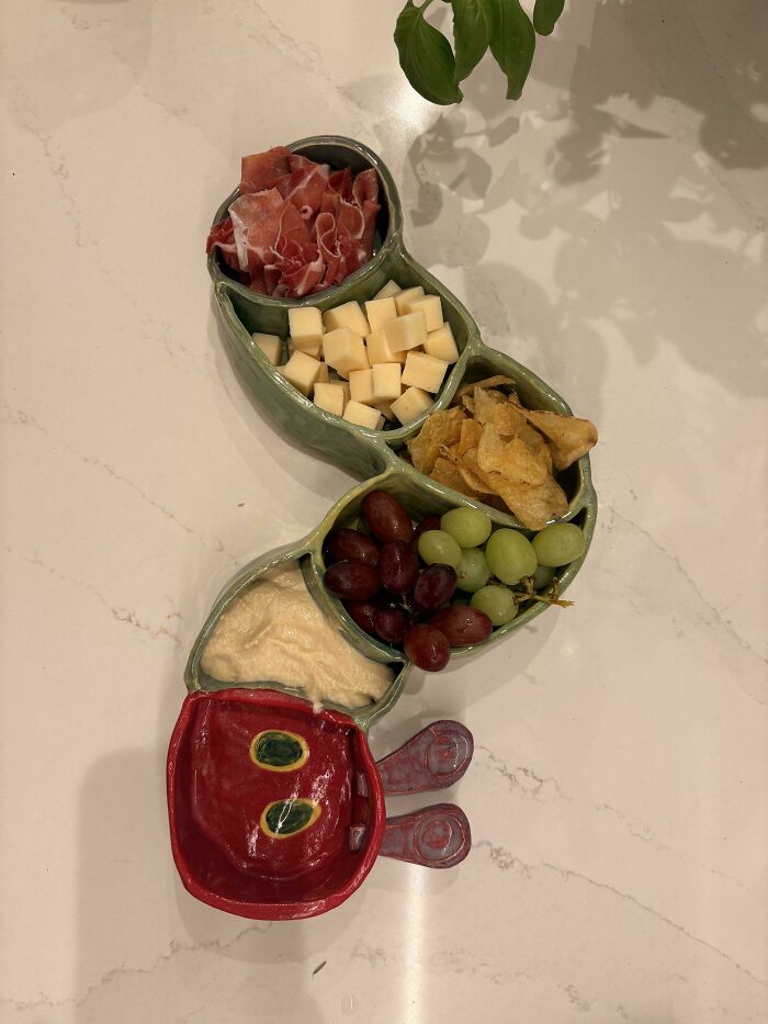 Caterpillar-shaped ceramic serving dish with snacks, an example of creative pottery creations