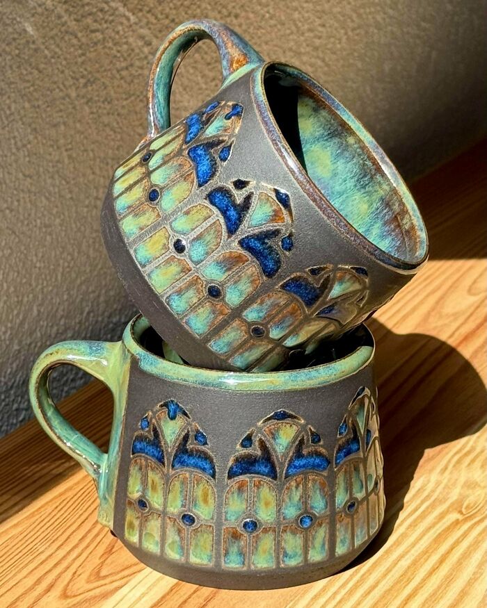 Two stacked ceramic mugs with stained glass inspired patterns as pottery creations