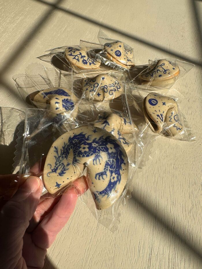 Individually wrapped ceramic fortune cookies with blue designs, illustrating unique pottery creations.