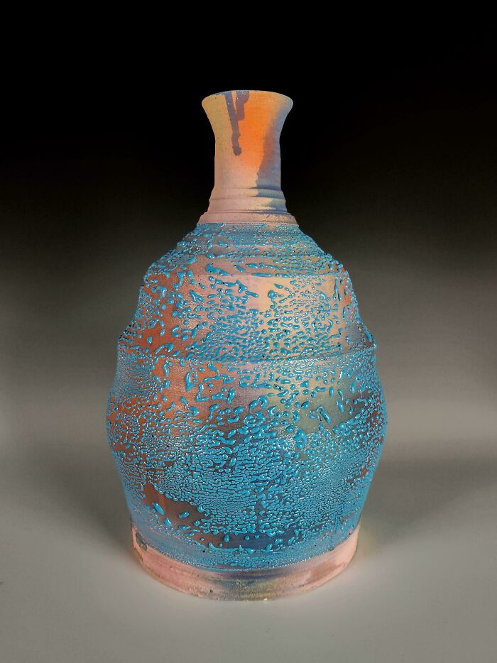Tall ceramic vase with textured blue splatter glaze demonstrating artistic pottery creations.