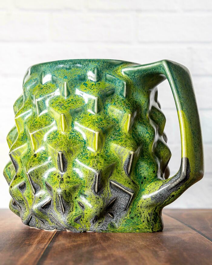 Textured green glazed mug showcasing unique handmade pottery creations.