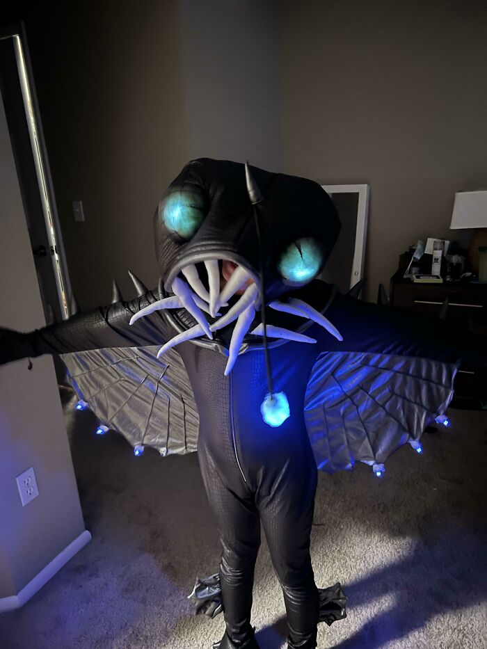 A child wearing a glowing anglerfish costume for Halloween with lights and detailed creature mask.