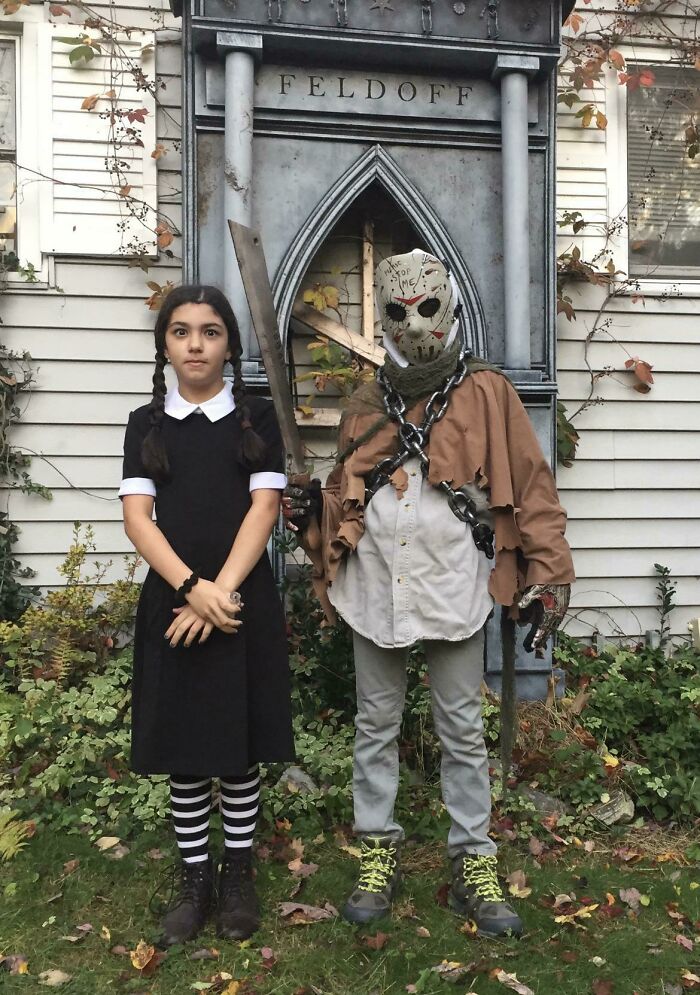 Two children wearing Wednesday Addams and Jason Voorhees kids Halloween costumes outside