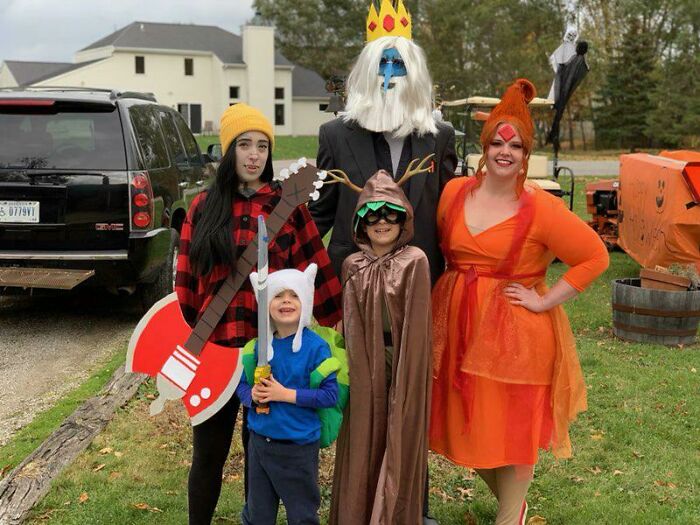 Group dressed up in Adventure Time kids Halloween costumes outdoors.