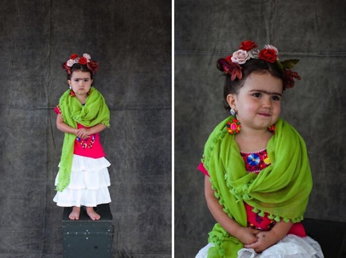 A young girl dressed up in Frida Kahlo kids Halloween costumes with flowers in her hair and a green scarf.