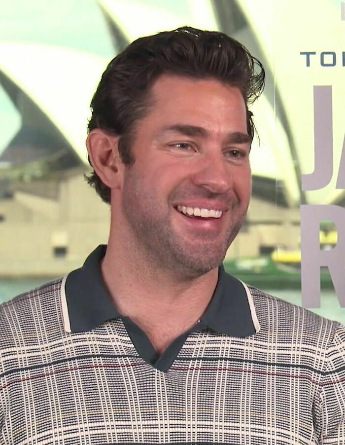 Actor John Krasinski smiling during an interview, highlighting his career in film and television.