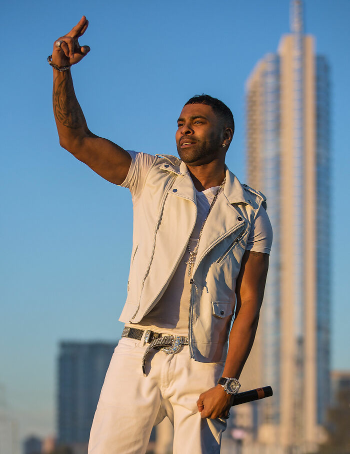 R&B singer Ginuwine performing outdoors in a white outfit during a career highlight moment