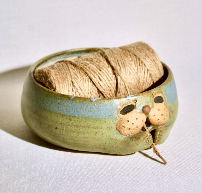 A small green and blue ceramic bowl holding twine, representing creative pottery creations.