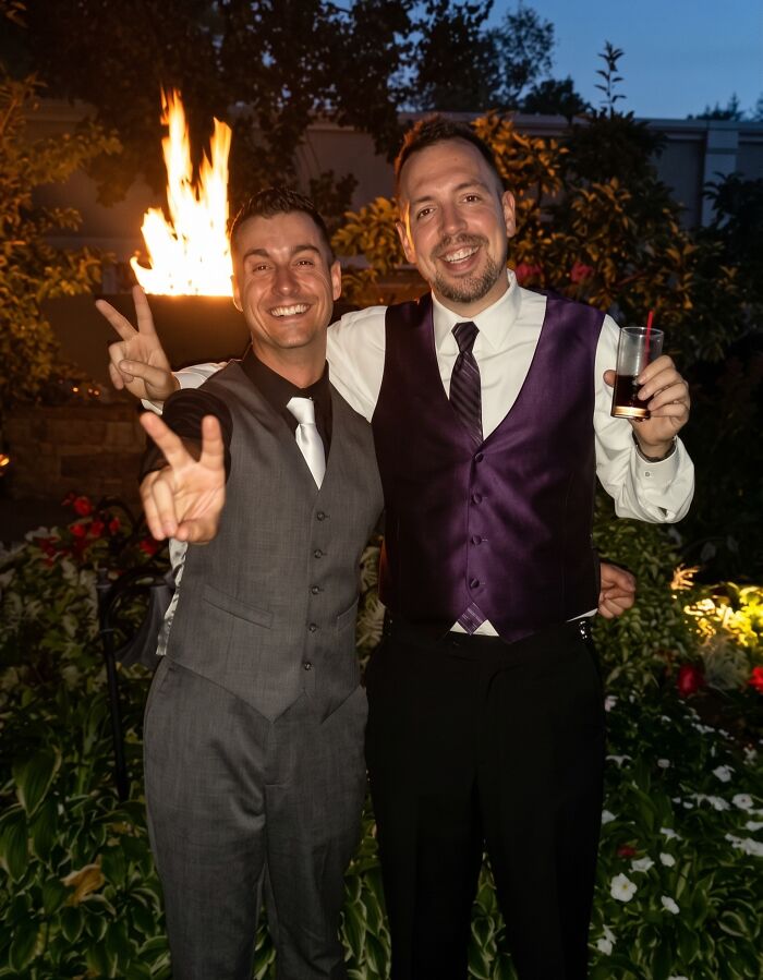 Two men in suits smiling and posing at an evening event