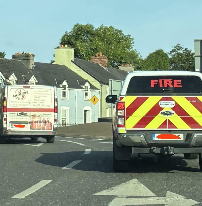 Fire service vehicle and antifire van near houses on a curved road
