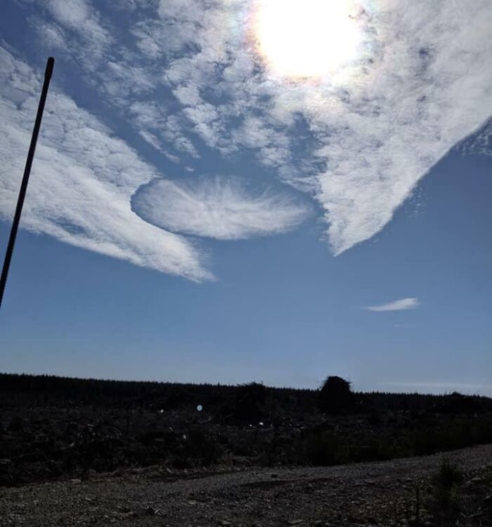 Sun shining through sky with unusual circular cloud formation glitch