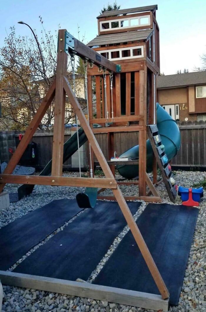Large wooden backyard playset with swings and a slide built for kids by caring dads.