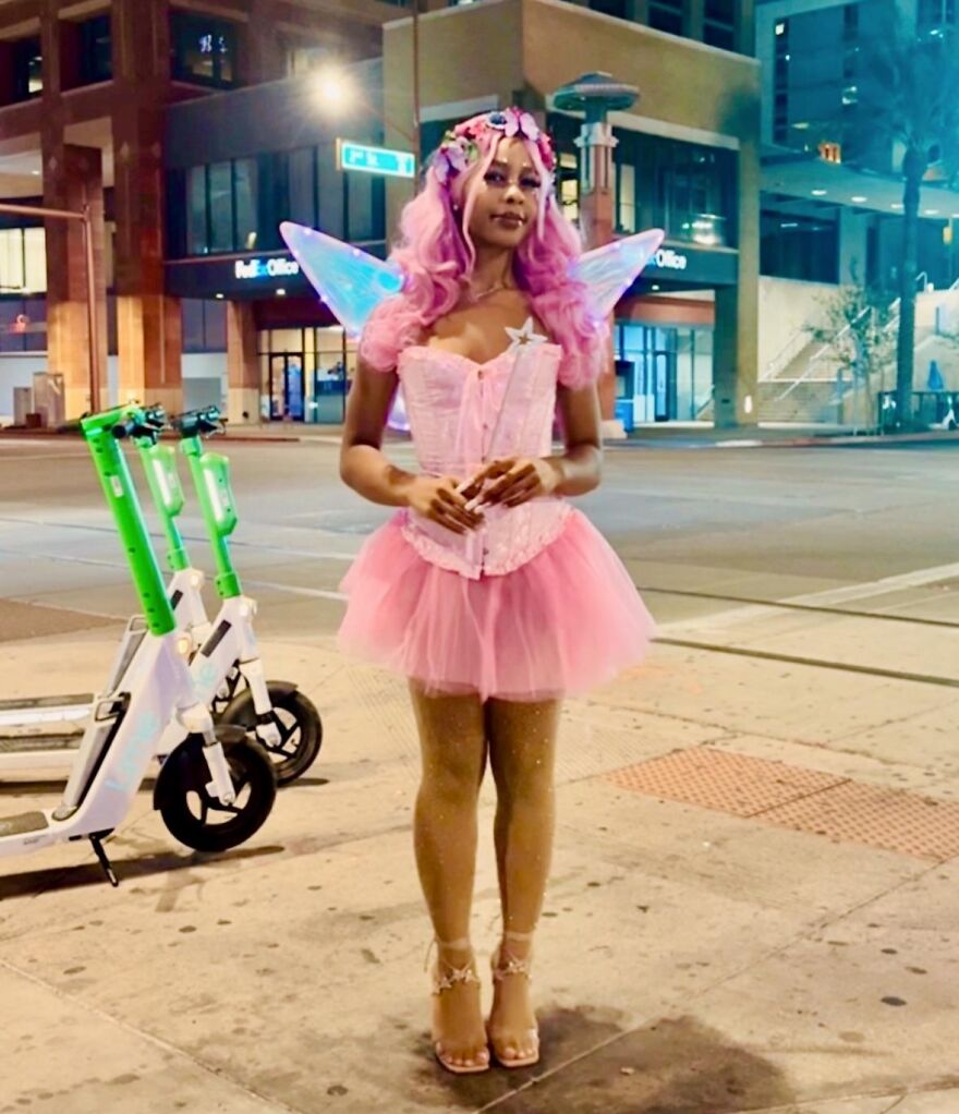 Woman dressed in a bright pink fairy outfit for a creative Halloween costume idea.