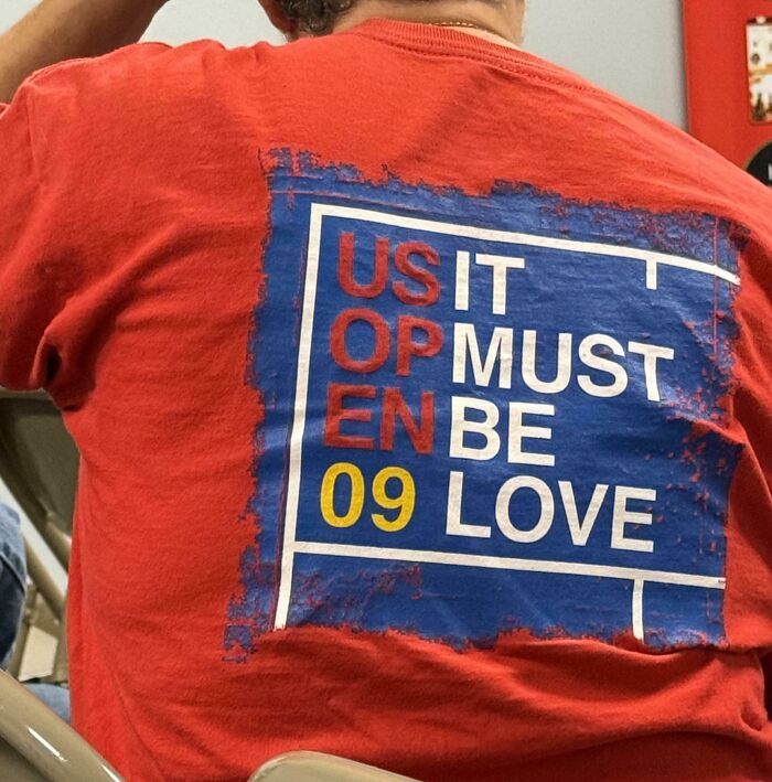 A person wearing a red t-shirt with a confusing graphic layout representing terribly designed signs.