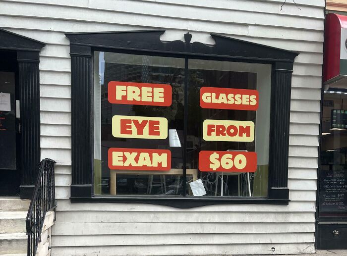 A storefront window with confusing signage about free eye exams and glasses, representing terribly designed signs.