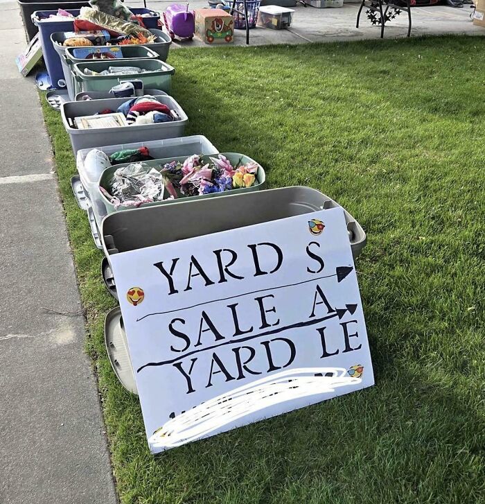 A hand-painted sign for a garage sale with mismatched and confusing word placement, an example of terribly designed signs.