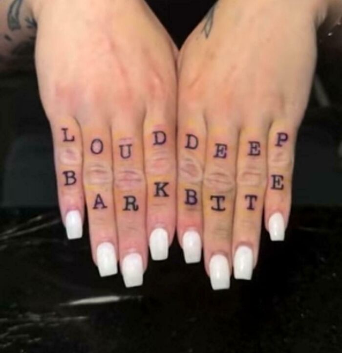 Finger tattoos with confusing vertical text alignment, an example of terribly designed signs.