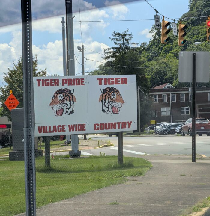 A roadside sign with confusing tiger mascot text, demonstrating terribly designed signs.
