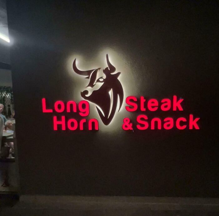 A glowing restaurant sign, an example of terribly designed signs with confusing layout.