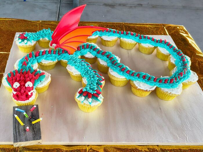 Creative dragon-shaped pull-apart birthday cupcakes made by devoted dads for a special celebration.