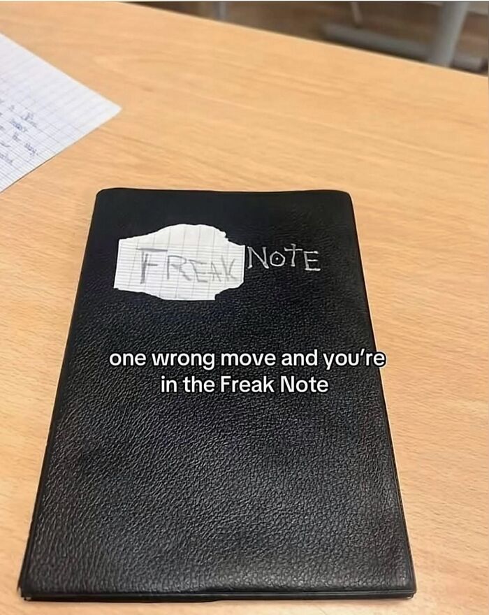 Hilarious meme of a black leather notebook labeled Freak Note lying on a wooden desk.