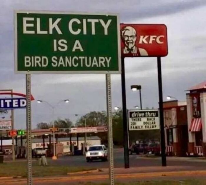 A sign saying Elk City is a bird sanctuary next to a KFC logo, a hilarious sign that clearly missed the mark.