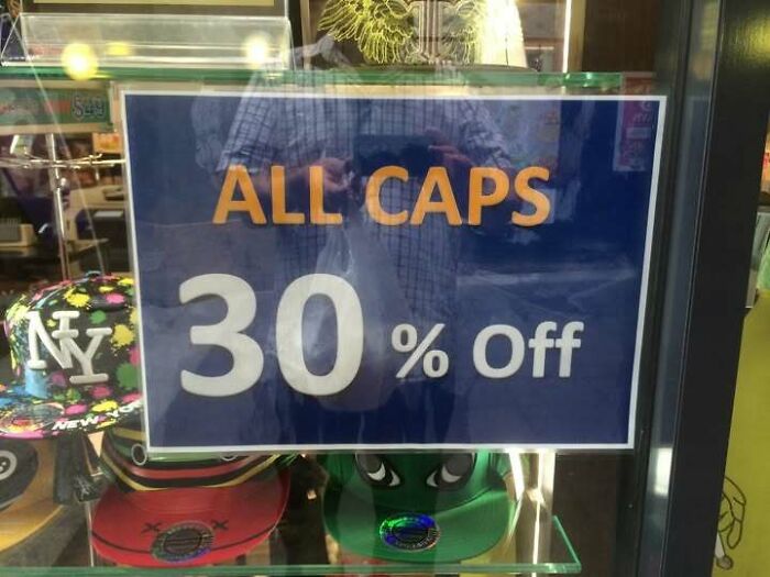 Funny store signs reading ALL CAPS 30% Off above baseball caps.