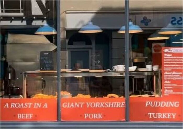 Hilarious ads: a restaurant window displaying poorly spaced text that creates a confusing menu description.